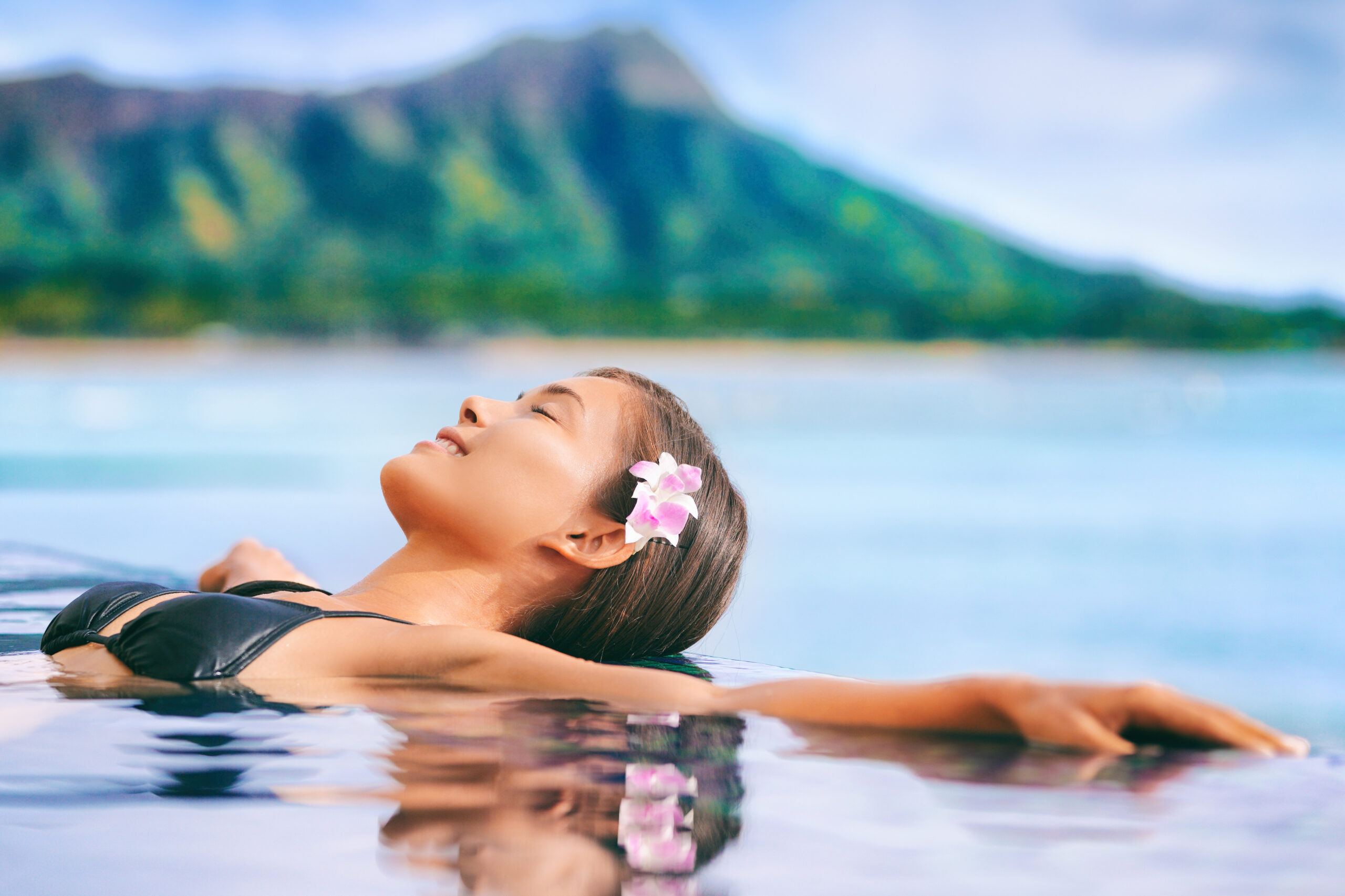 Hawaii vacation luxury resort travel Asian tourist girl relaxing in hotel  infinity pool by Waikiki beach in Honolulu, Oahu. USA travel. - Le Cameleon  Hotel Puerto Viejo